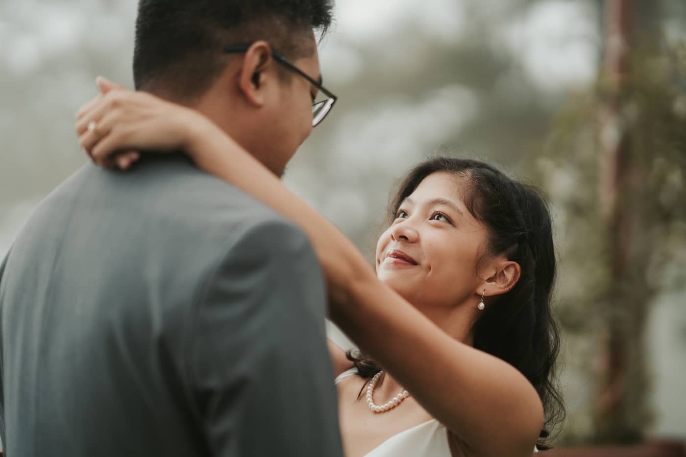 A close embrace, her arms around his neck as she gazes up at him